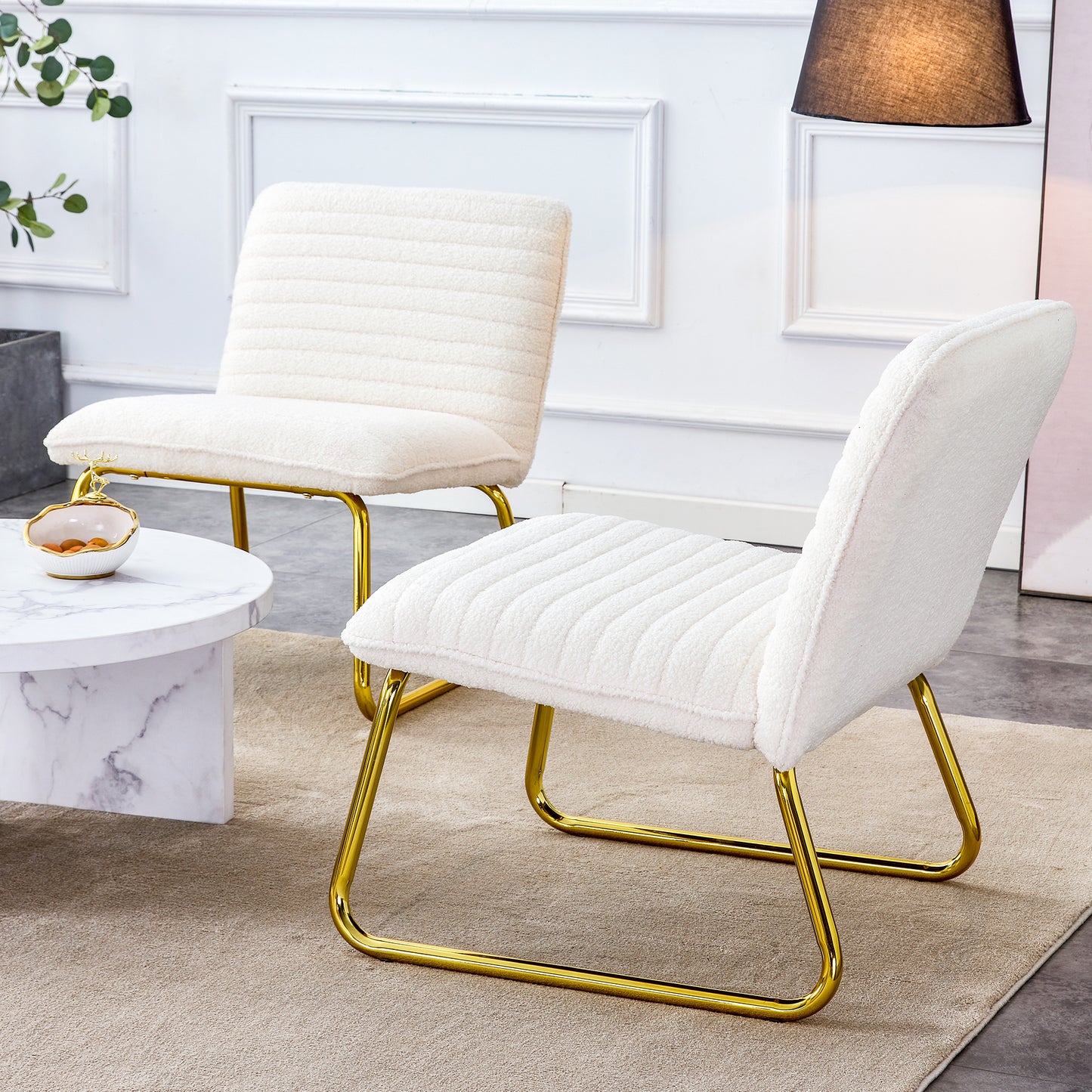 One White minimalist armless sofa chair with plush cushion and backrest paired with golden metal legs