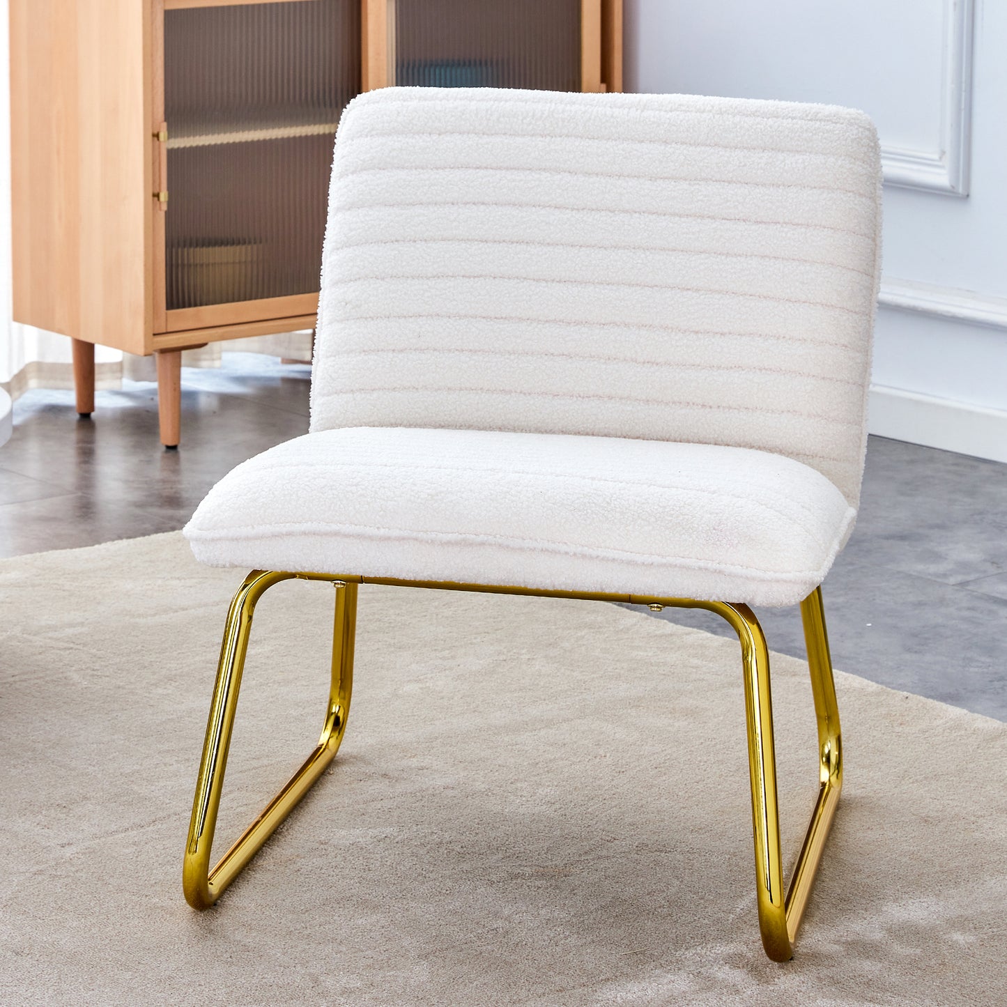 One White minimalist armless sofa chair with plush cushion and backrest paired with golden metal legs