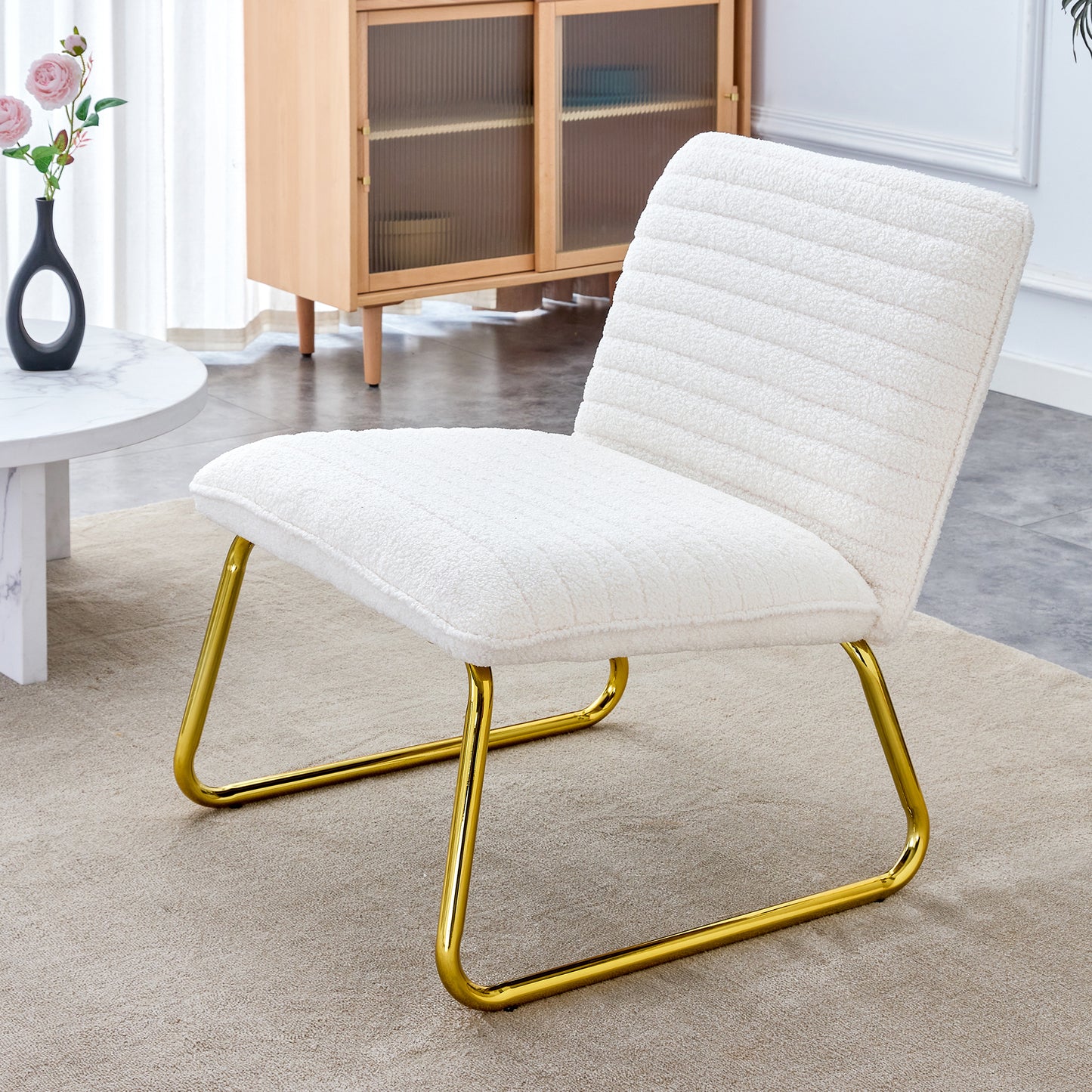 One White minimalist armless sofa chair with plush cushion and backrest paired with golden metal legs